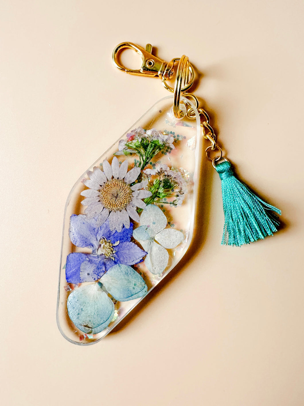 purple/teal dried floral keychain with iridescent flakes